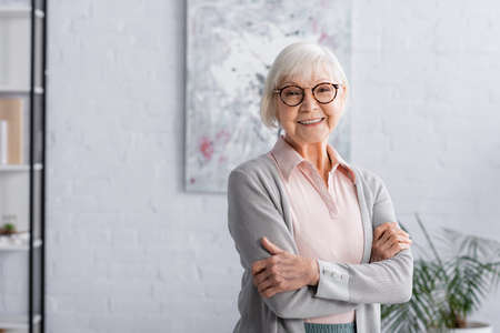 Smiling elderly woman in eyeglasses looking at camera