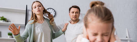 Man holding hair of wife near scared kid on blurred foreground, bannerの写真素材