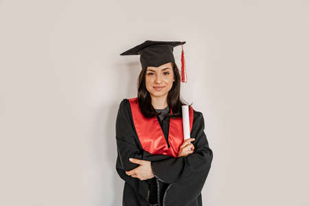 happy student in graduation cap and gown holding diploma, senior 2021の写真素材