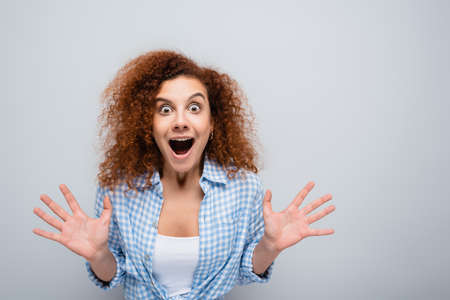 astonished woman with open mouth showing wow gesture isolated on gray