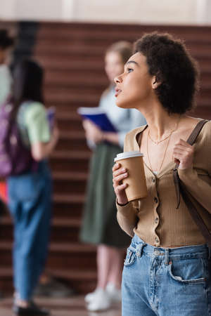 African american student with bag and coffee to go in university