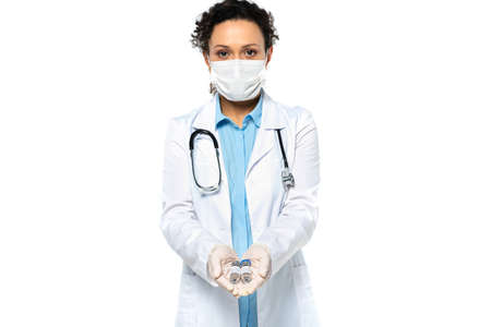 African american doctor in medical mask holding vaccine in hands isolated on whiteの写真素材