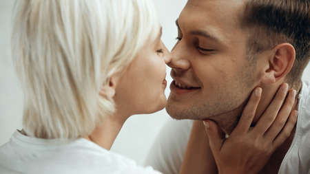 close up of happy young couple kissing at home