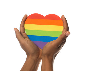 cropped view of african american man with rainbow colors paper heart isolated on white, lgbt conceptの写真素材