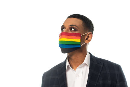 african american businessman wearing medical mask in lgbt colors and looking away isolated on whiteの写真素材