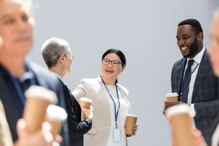 selective focus of happy interracial business colleagues talking during conference