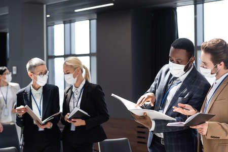 african american businessman pointing at documents during conversation with colleagueの写真素材