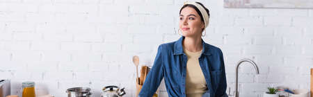 Housewife looking away in kitchen, bannerの写真素材