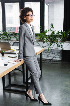 Young african american manager standing near gadgets on tableの写真素材