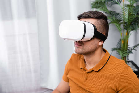 young man gaming in vr headset at home