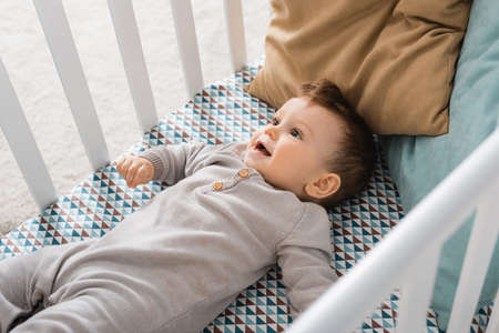 high angle view of infant boy lying in baby crib