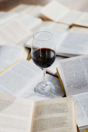 glass of red wine on pile of booksの写真素材