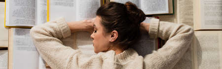 top view of tired woman sleeping near open books, bannerの写真素材