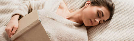 top view of young woman sleeping with book on bed, banner