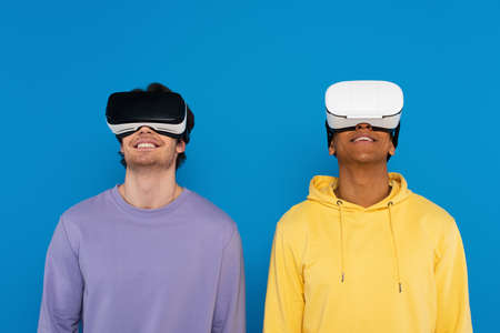 interracial hipsters in virtual reality headsets isolated on blueの写真素材