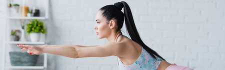 side view of brunette woman training with outstretched hands, bannerの写真素材