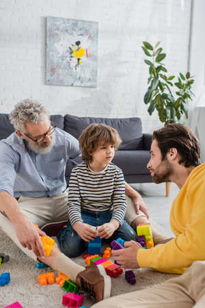Parents playing building blocks with kid