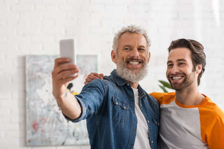 Mature man taking selfie with smiling sonの写真素材