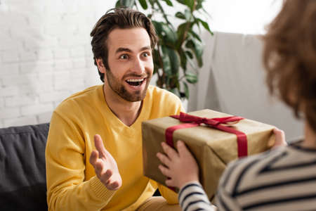 Cheerful man looking at blurred son with presentの写真素材