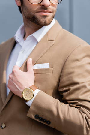 partial view of businessman in beige suit and wristwatchの写真素材
