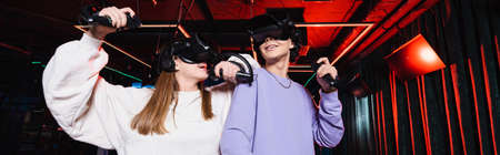happy teenage gamers in headsets having fun in vr game zone, banner