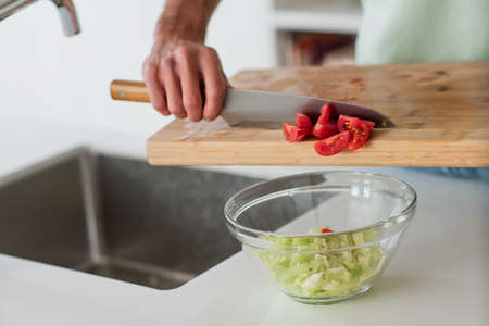 partial view of man preparing fresh vegetable salad for breakfast