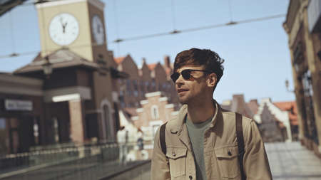 stylish man in sunglasses smiling outside