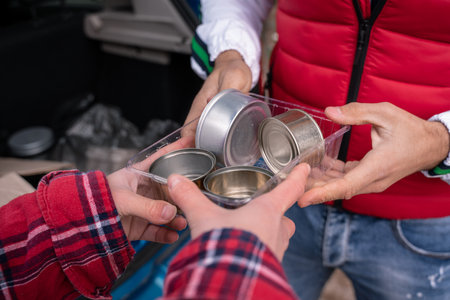 cropped view of man and woman holding tin cans in plastic containerの写真素材