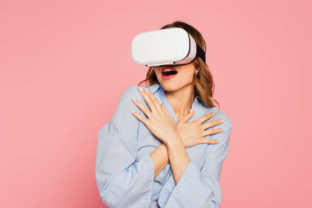 Scared woman in vr headset isolated on pink