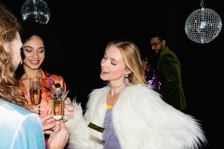 multiracial friends having drink in night club on black backgroundの写真素材