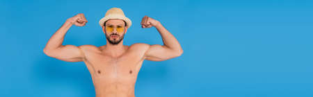 Shirtless man in sun hat showing muscles on blue background, bannerの写真素材
