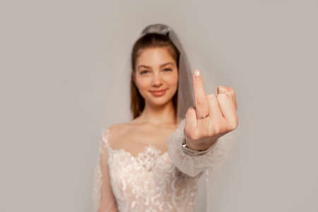 blurred bride showing finger with wedding ring isolated on grayの写真素材