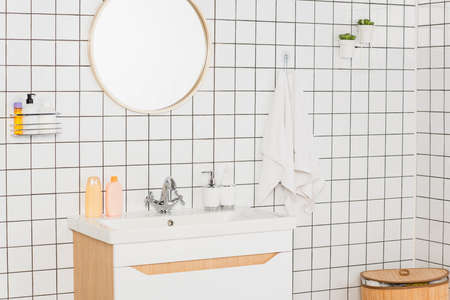 interior view of modern bright bathroom with washbasin, mirror, toiletries and towelsの写真素材