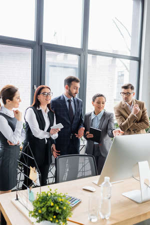 Multiethnic businesspeople standing near computer in office