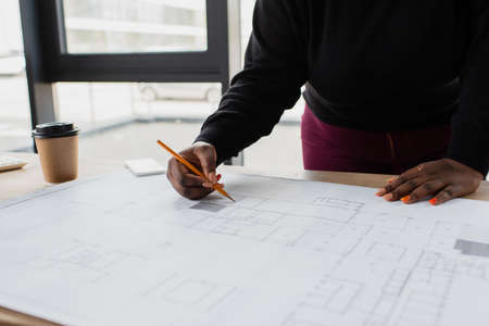 cropped view of african american plus size engineer drawing blueprintの写真素材