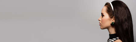 side view of pretty young model posing isolated on gray, bannerの写真素材