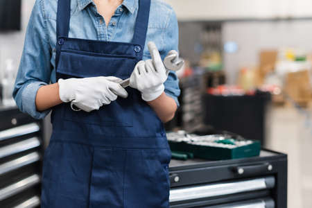 cropped view of young african american mechanic holding wrench in auto repair service