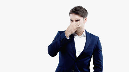 Disgusted businessman covering nose isolated on whiteの写真素材