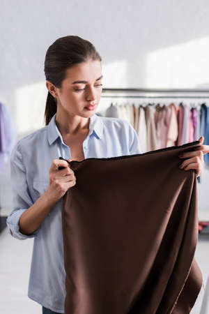 Seamstress holding cloth in designer studioの写真素材