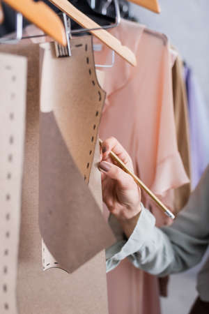 Cropped view of designer with pencil touching sewing patternsの写真素材