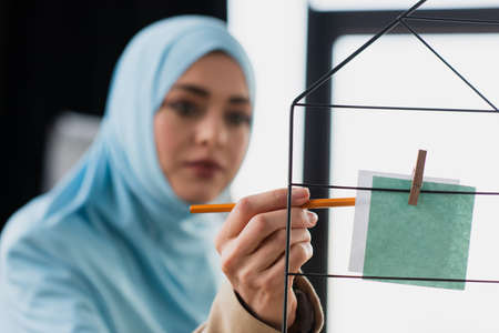 blurred muslim businesswoman pointing with pencil at paper noteの写真素材