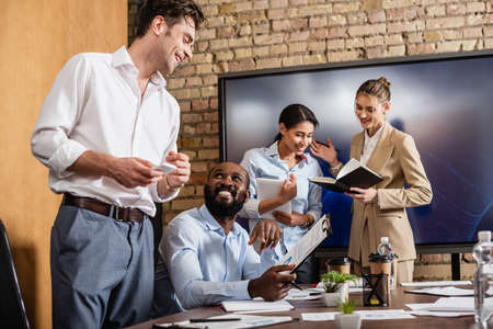 positive interracial businesspeople talking in conference room