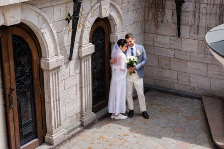 Smiling newlyweds hugging near building outdoorsの写真素材