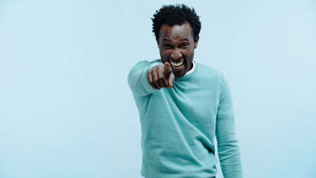 happy african american man pointing with finger at camera isolated on blue