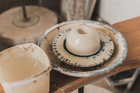 pottery wheel with wet clay on wooden bench in art studioの写真素材