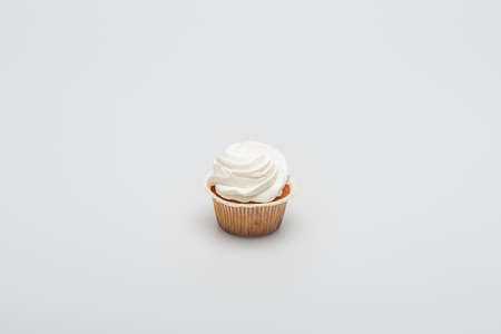 baked tasty cupcake with icing on top on whiteの写真素材