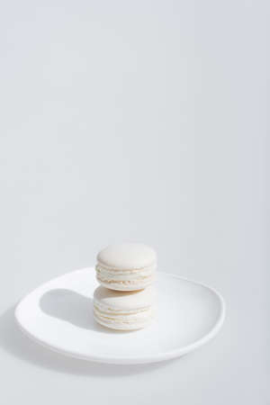 tasty and sweet macarons on plate isolated in whiteの写真素材