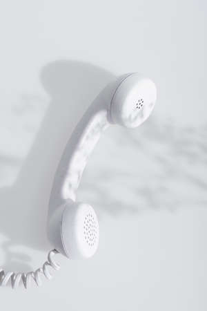 top view of shadows near retro handset on white