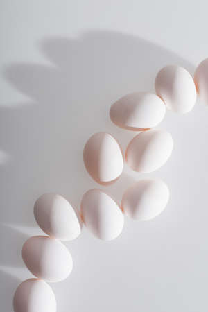 top view of fresh and organic eggs in shell on white