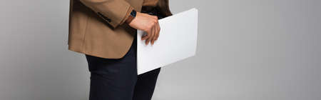 Cropped view of businessman holding paperwork isolated on gray, bannerの写真素材